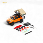 Model toy truck with rooftop tent and accessories on a white background