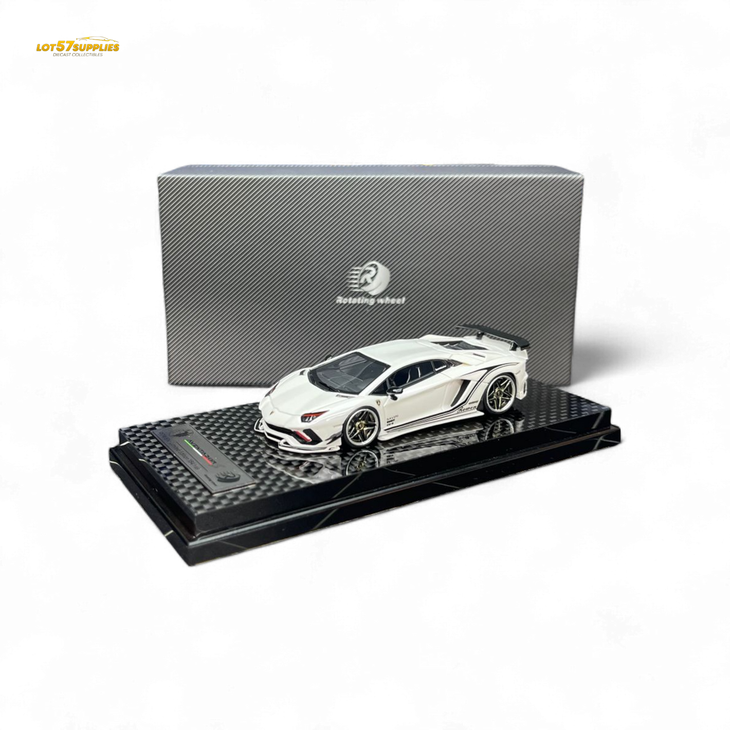 White sports car model on a black display stand with a branded box in the background