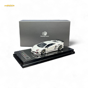 White sports car model on a black display stand with a branded box in the background
