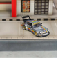 SW RWB Porsche 964 High Wing Apple Racing Livery 1:64 diecast model, front three-quarter view on a street diorama