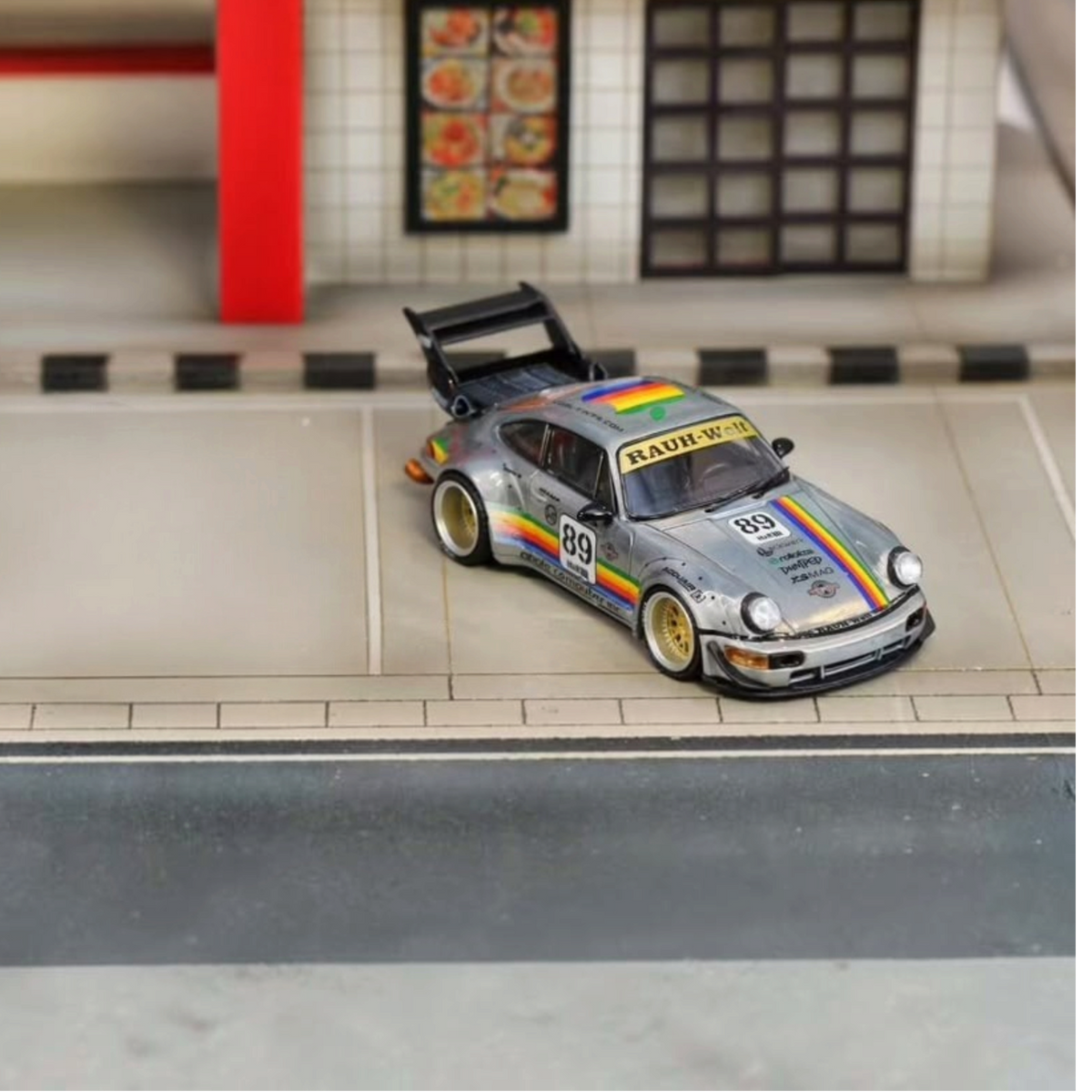 SW RWB Porsche 964 High Wing Apple Racing Livery 1:64 diecast model, front three-quarter view on a street diorama