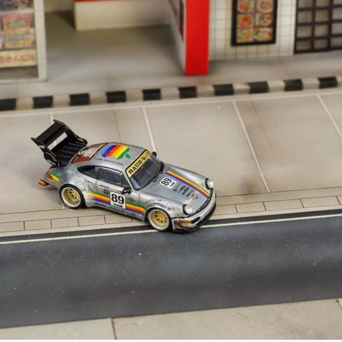 SW RWB Porsche 964 High Wing Apple Racing Livery 1:64 diecast model, front three-quarter view on a street diorama