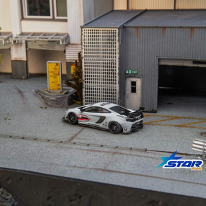 Star Models McLaren 650S Wide-Body Air Force Grey Shark Mouth 1:64 diecast, rear three-quarter in a garage diorama