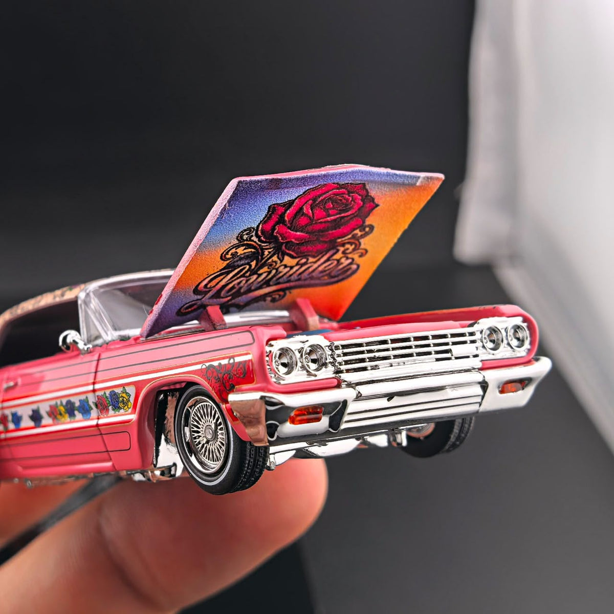 Gypsy Rose Impala held in hand with the hood up showing rose Lowrider art under the hood
