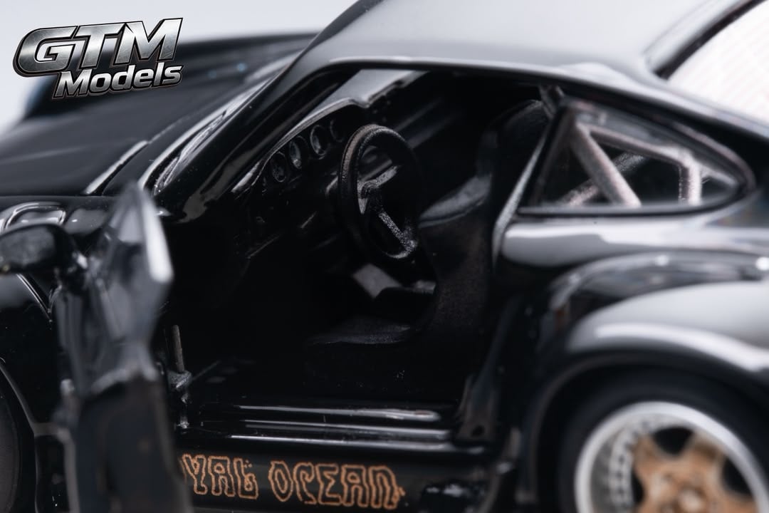 Close-up of the open driver door showing the RWB 993 interior and roll cage