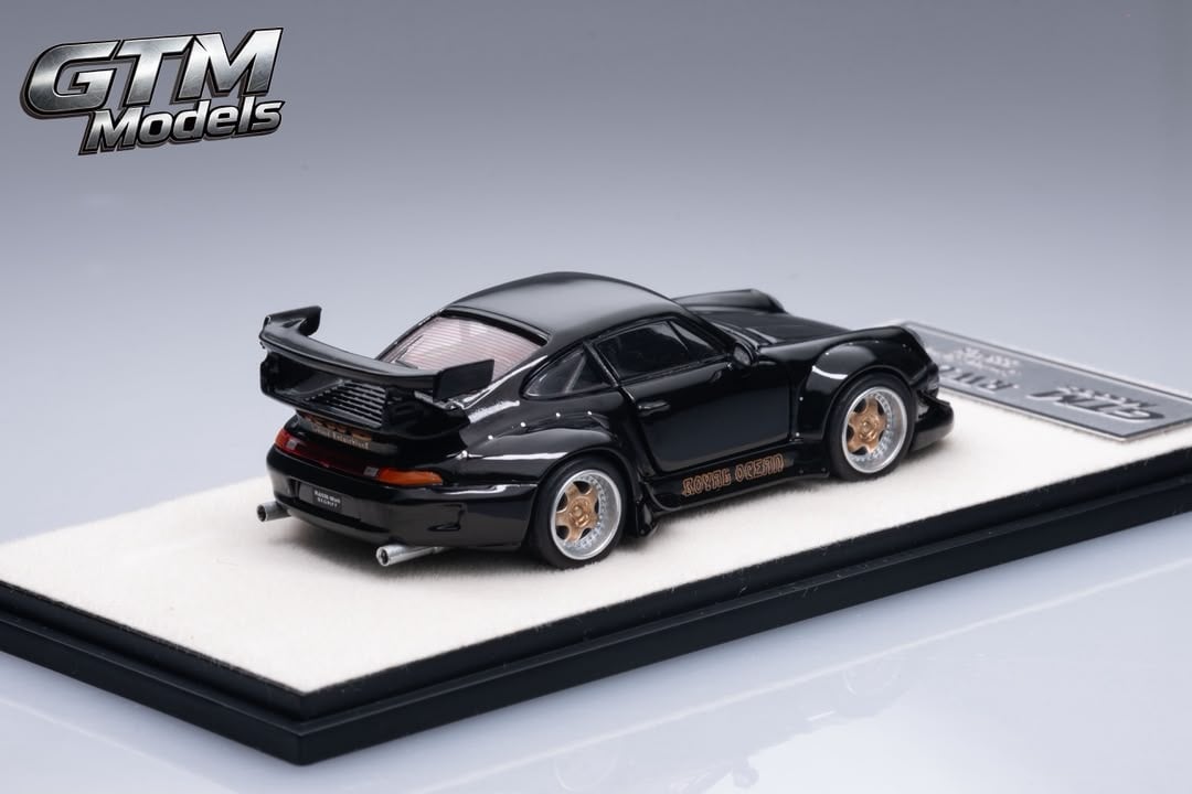 Rear three-quarter view of the black RWB 993 with ducktail wing and bronze wheels