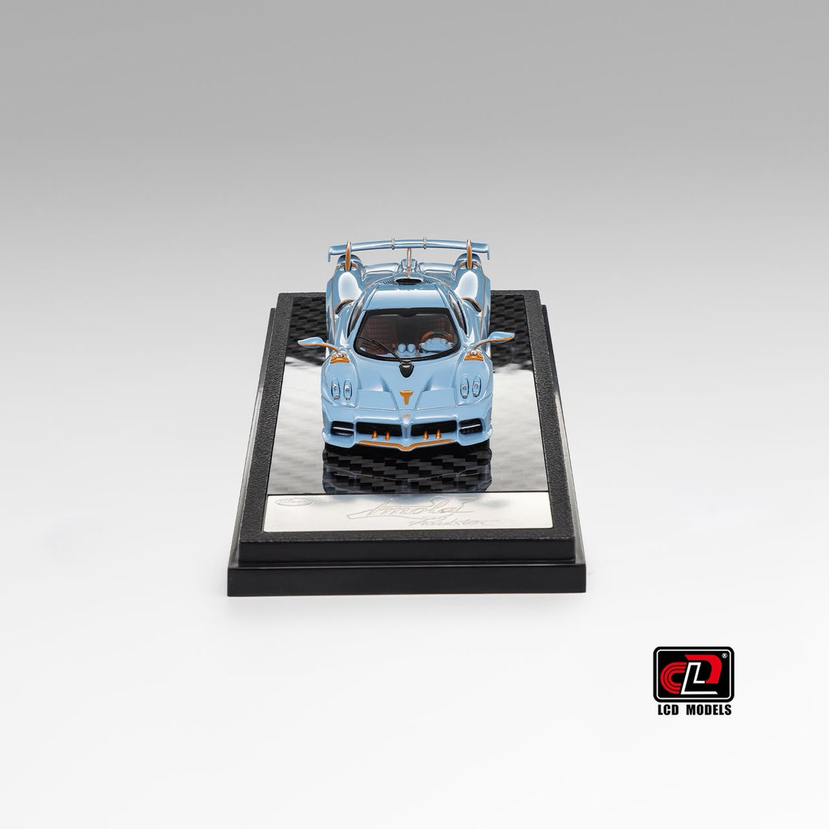 LCD Pagani Imola Roadster light blue 1:64, head-on front view with hood and both doors opened up above the engraved base plaque