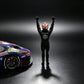 Driver figure in a black race suit and Red Bull helmet, arms raised, seen from behind beside the MechSpeed 296GT3 1:64 in blue Red Bull livery