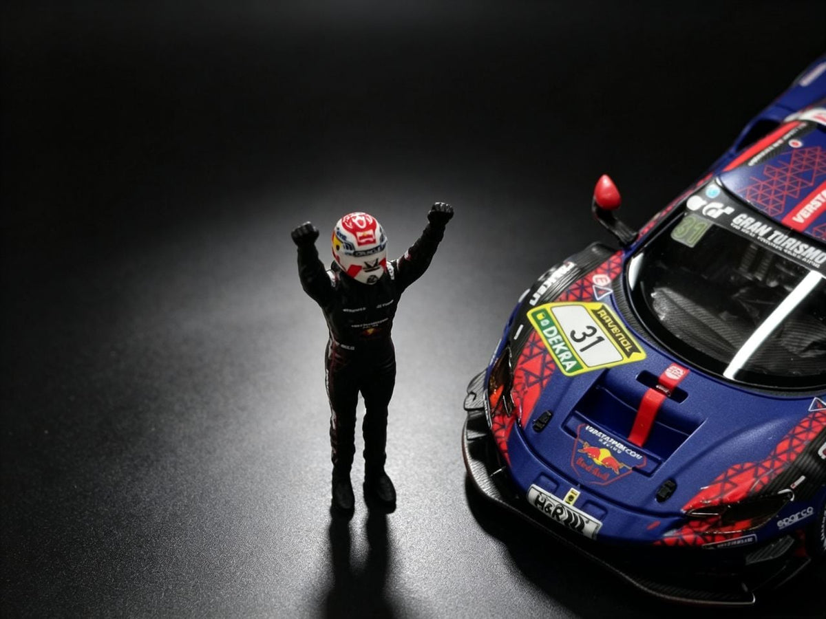 Close-up of the MechSpeed 296GT3 1:64 nose in blue Red Bull livery with the DEKRA 31 roundel, beside a driver figure with both arms raised