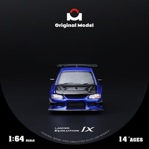 Original Model Mitsubishi Lancer Evolution IX 1:64 in metallic blue, head-on front view with carbon vented bonnet and black GT wing above the roof.