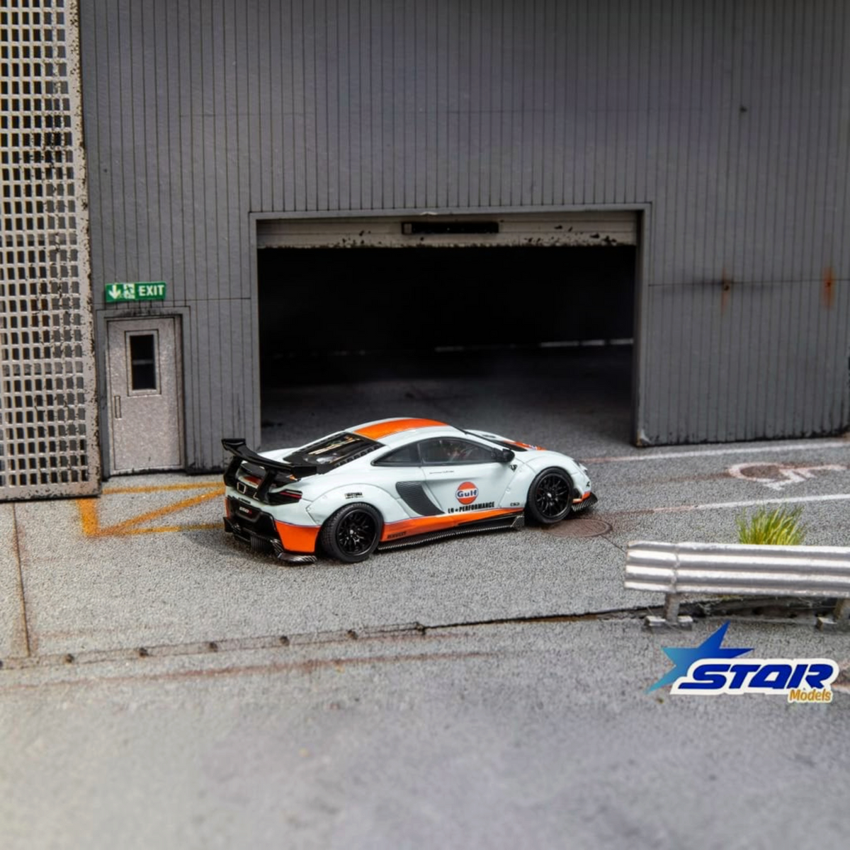 Star Models McLaren 650S Wide-Body Gulf Livery (Ltd 699) 1:64 diecast, rear three-quarter in a garage diorama