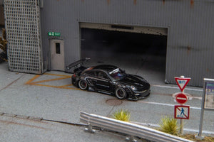 Star Models 1:64 Porsche 997 widebody in gloss black, front three-quarter from the right