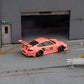 Star Models 1:64 Porsche 997 widebody in Pink Pig livery with number 23 roundel, rear three-quarter showing the large rear wing and butcher-cut graphics