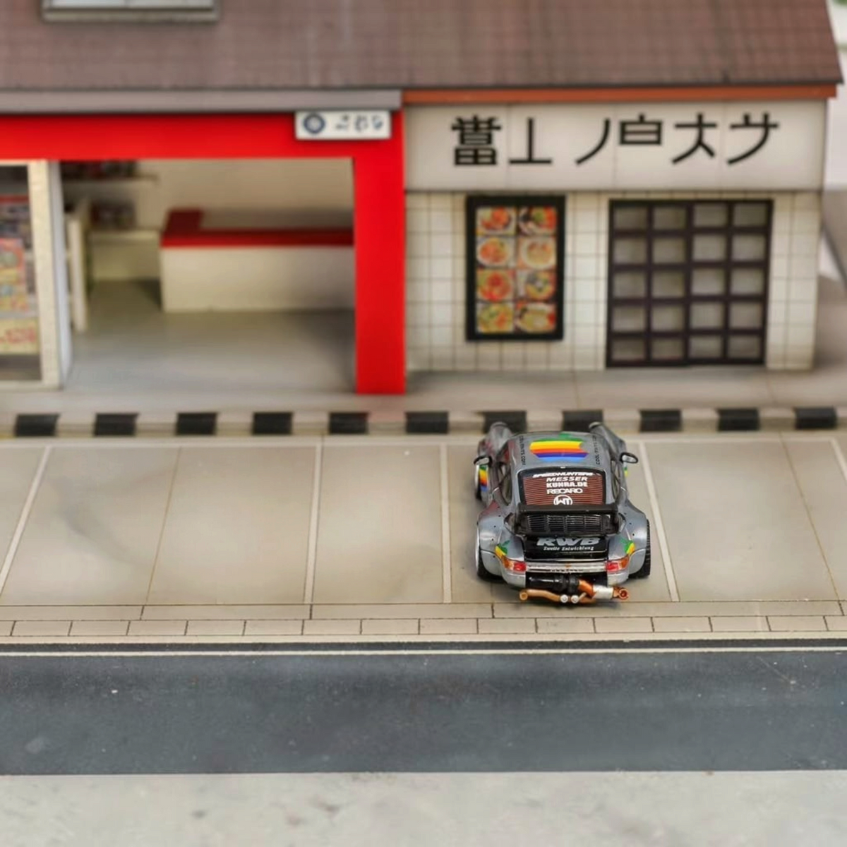SW RWB Porsche 993 Apple Racing Livery Low Wing 1:64 diecast model, rear view in a Japanese street diorama