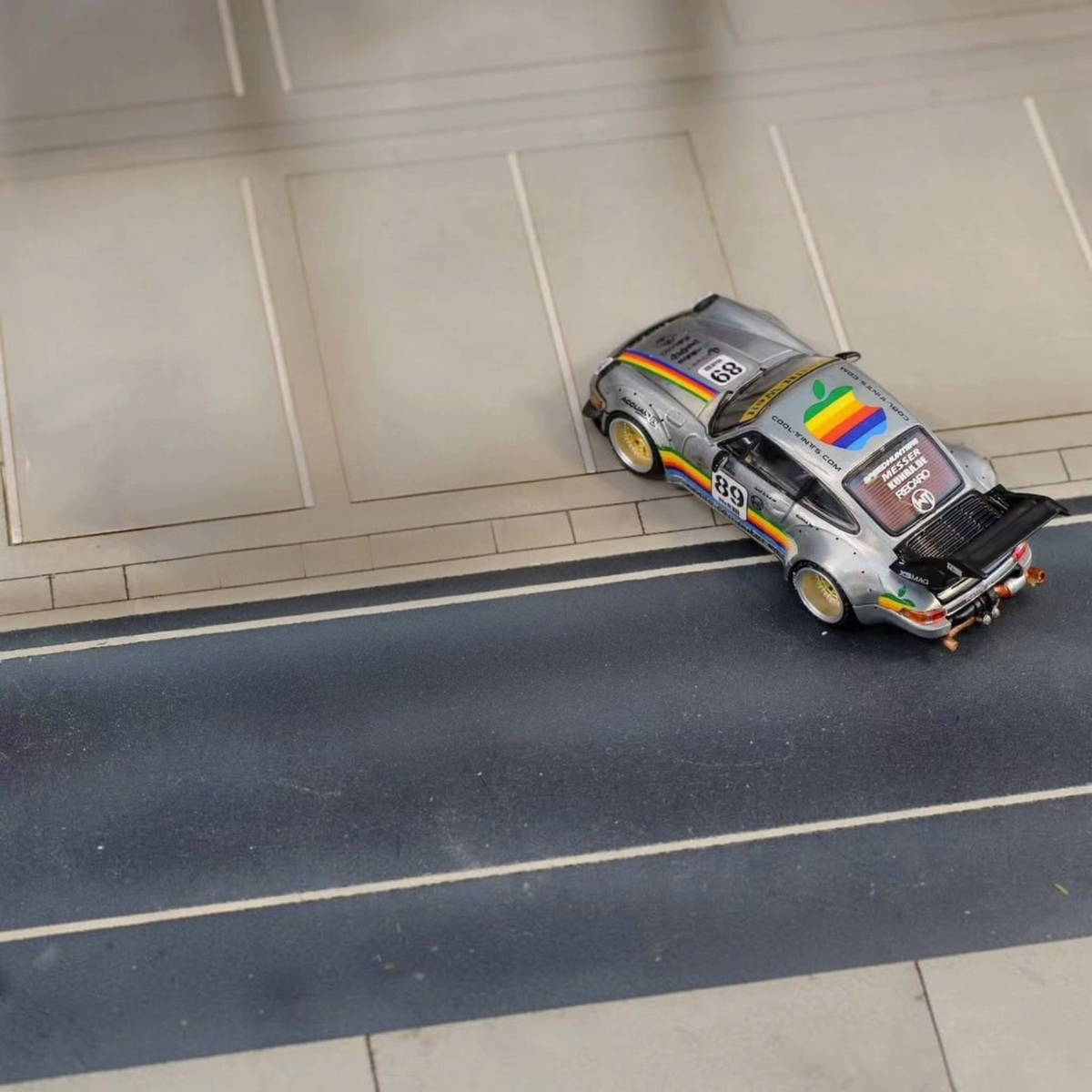 SW RWB Porsche 993 Apple Racing Livery Low Wing 1:64 diecast, high-angle rear three-quarter on a road diorama