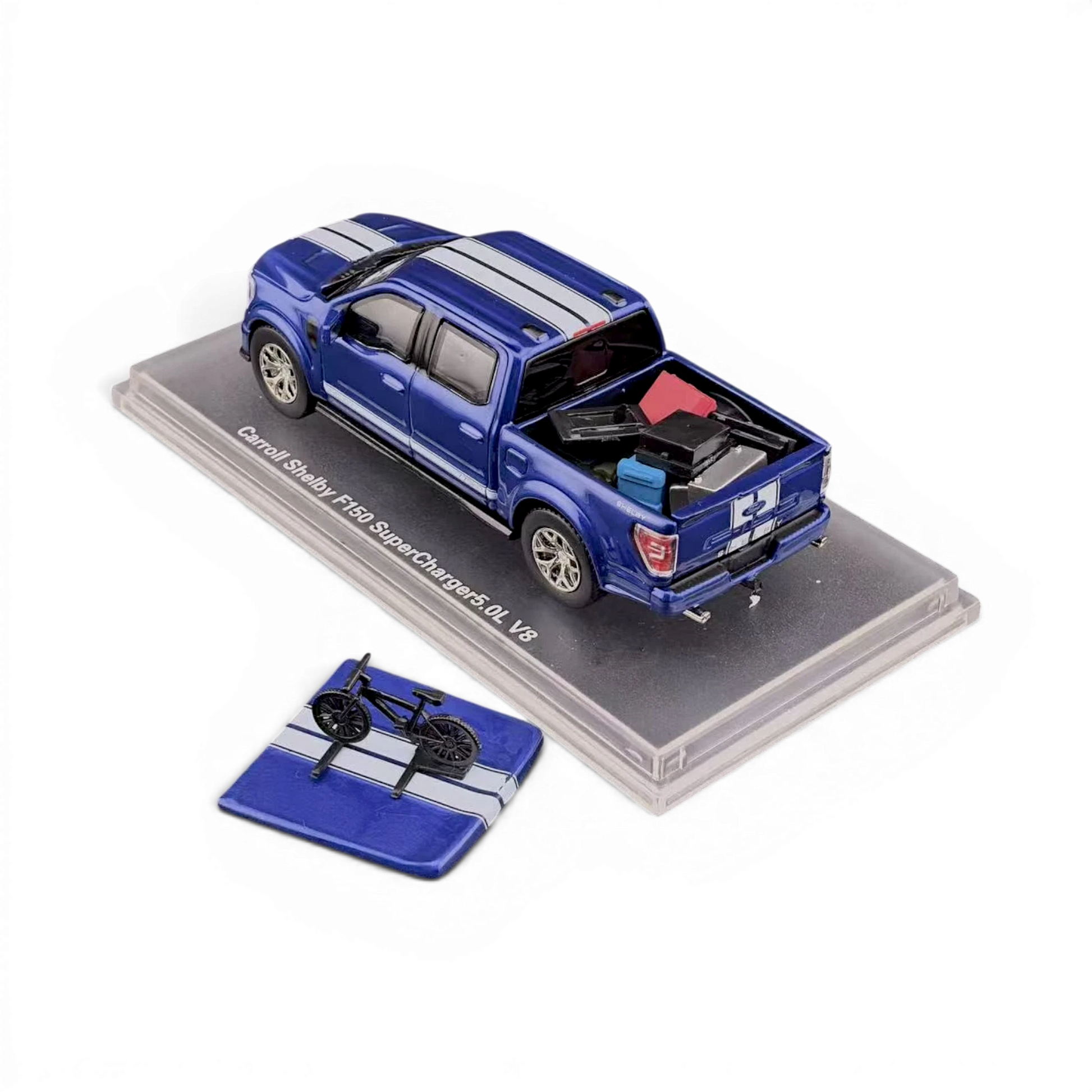 Lot57Supplies Diecast Shop 1:64 blue Ford Shelby F-150 pickup truck with white racing stripes, detailed interior, and cargo in the bed. Includes a separate display piece with a miniature bicycle.