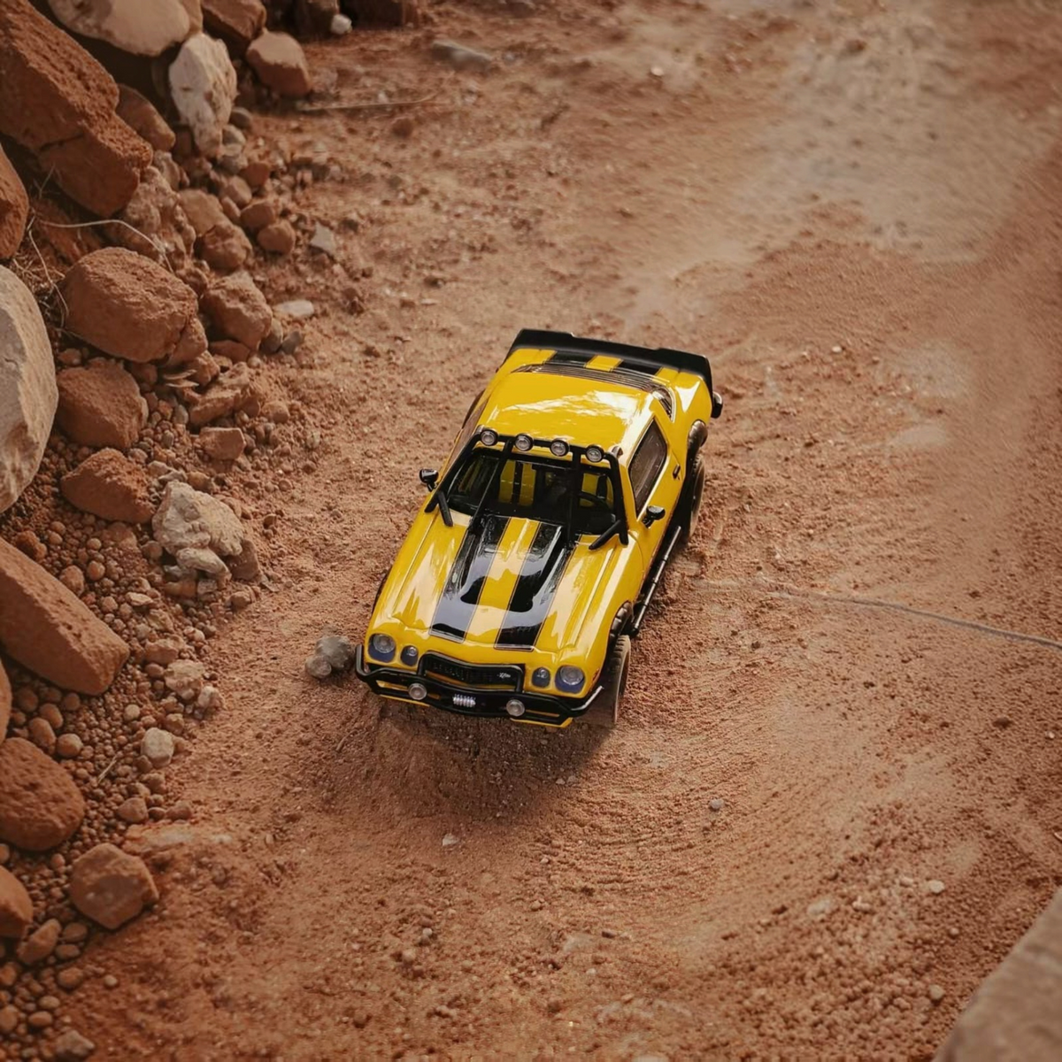 Lot57Supplies Diecast Shop bliss 1:64 scale 1978 Camaro Bumblebee edition diecast car on a rocky dirt terrain