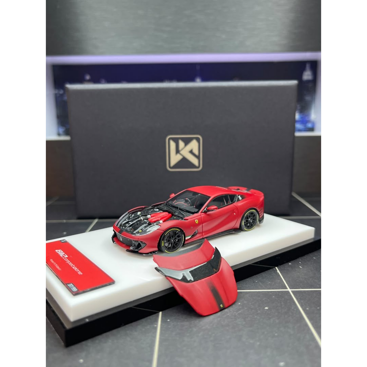 Lot57Supplies Diecast Shop DMY Ferrari 812C matte red 1:64 scale model car with opening hood on display stand