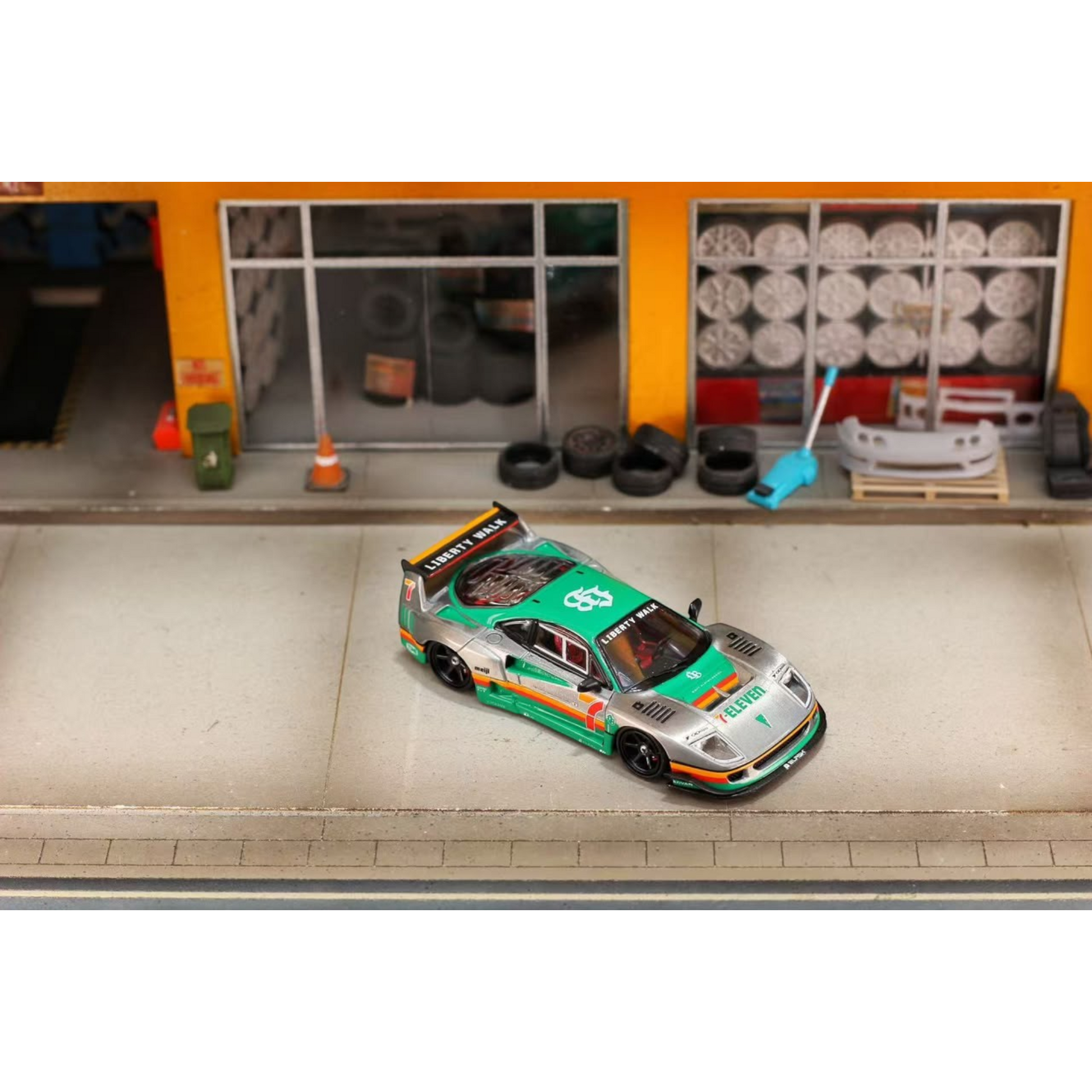 Lot57Supplies Diecast Shop GHOST PLAYER Ferrari F40 1:64 scale diecast model with 7-Eleven livery in a garage diorama