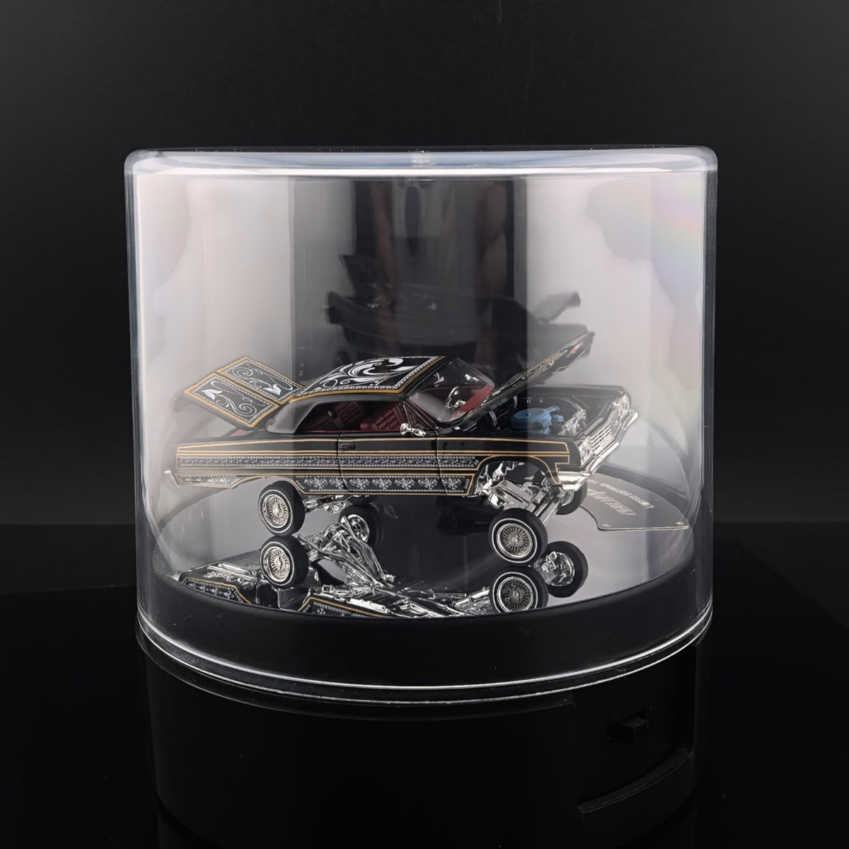 Lot57Supplies Diecast Shop Fine Works64 black and gold Impala lowrider diecast car on an electric turntable display