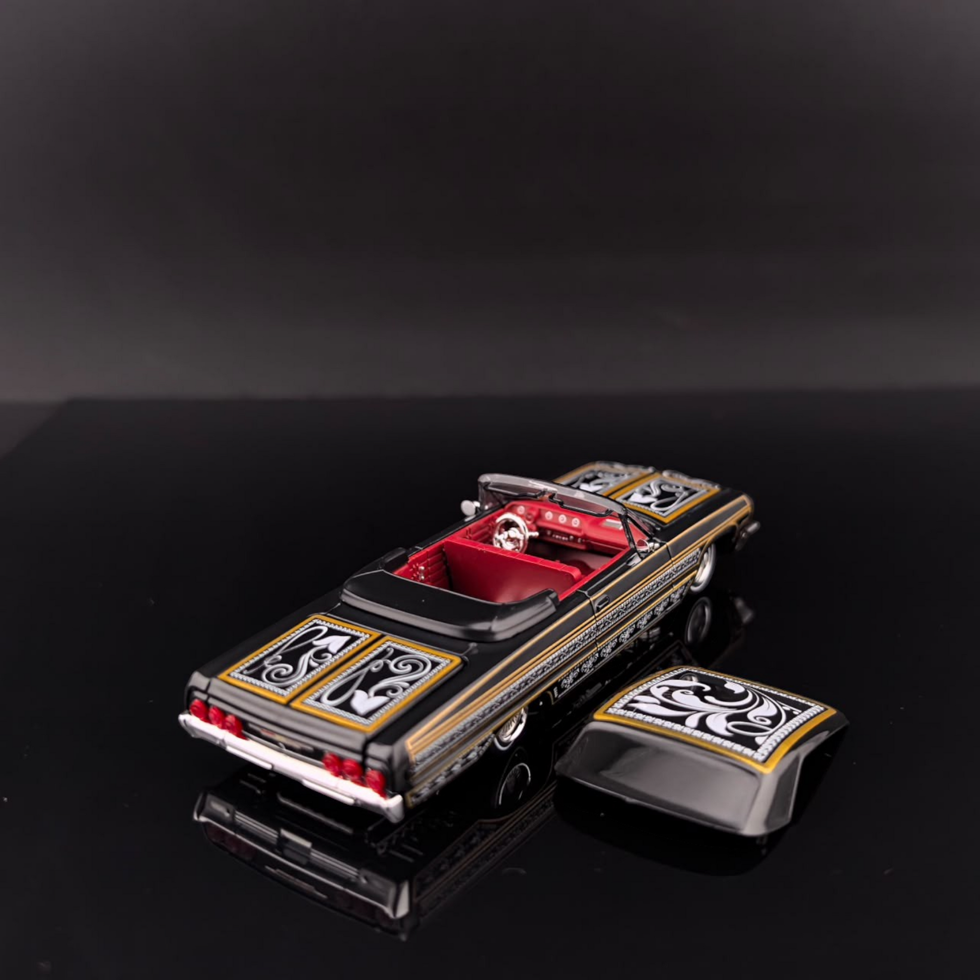 Lot57Supplies Diecast Shop 1:64 scale black and gold Impala lowrider diecast car with red interior and custom decals.
