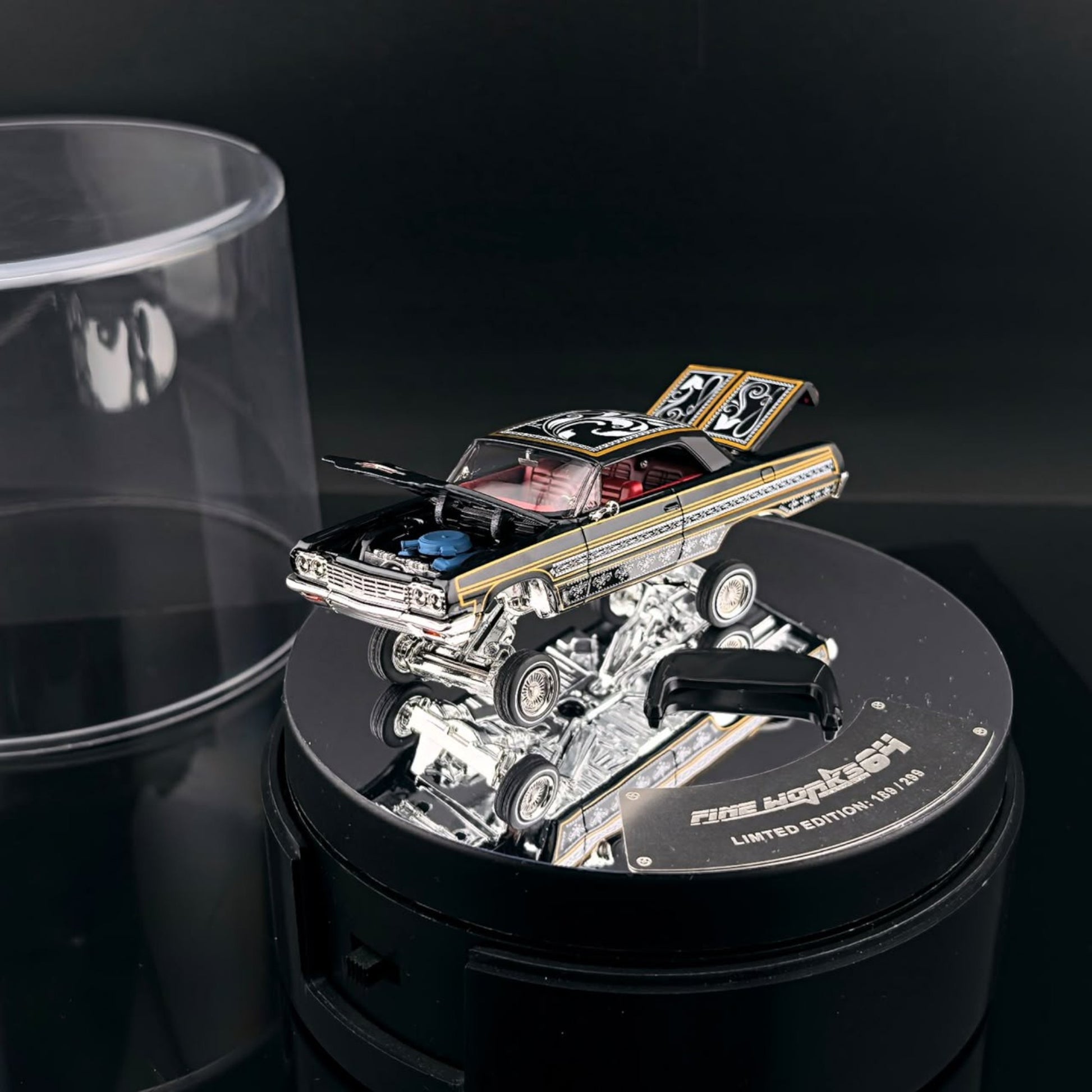 Lot57Supplies Diecast Shop Fine Works64 black and gold Impala lowrider diecast car on an electric display turntable