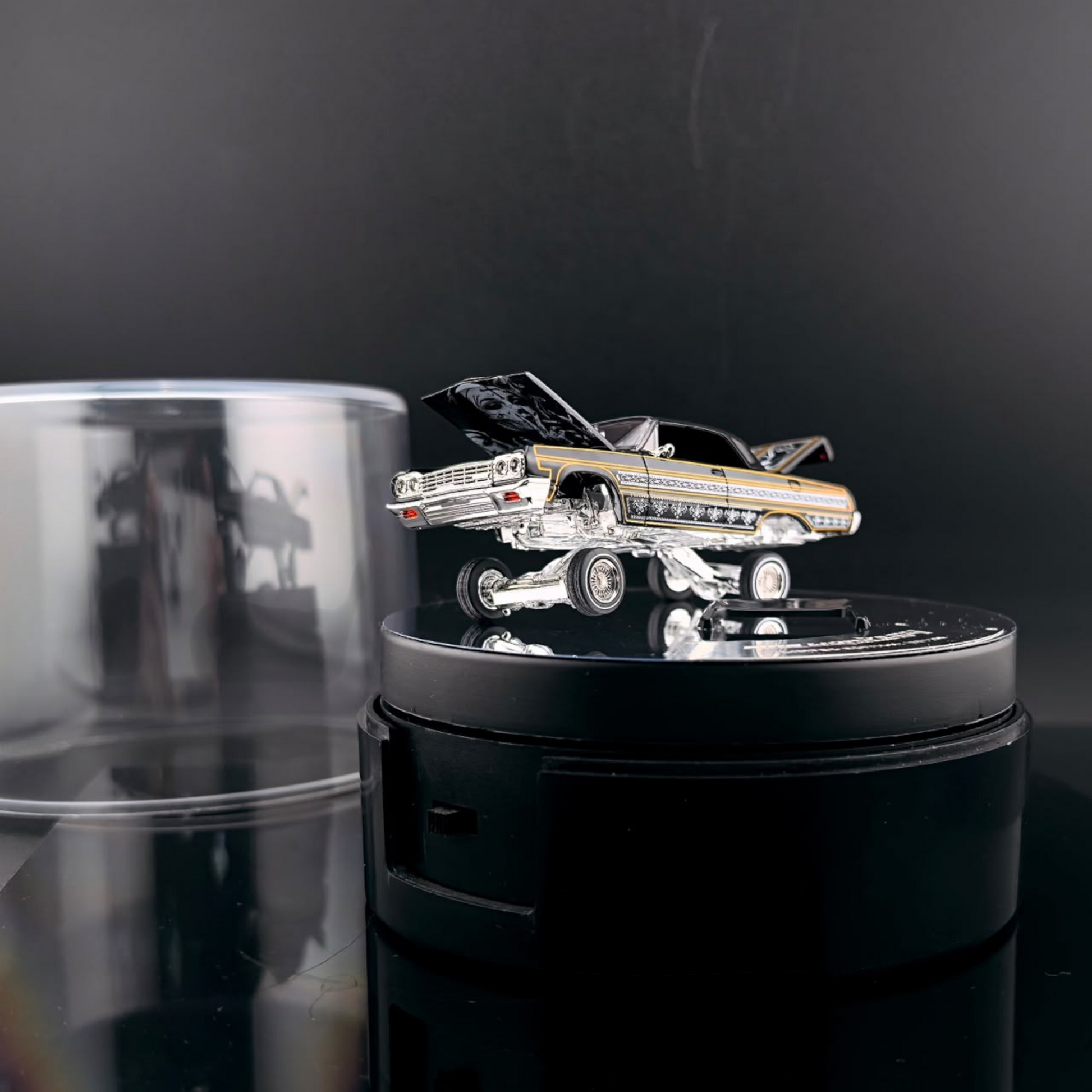 Lot57Supplies Diecast Shop Fine Works64 Impala lowrider diecast car in black and gold on an electric turntable
