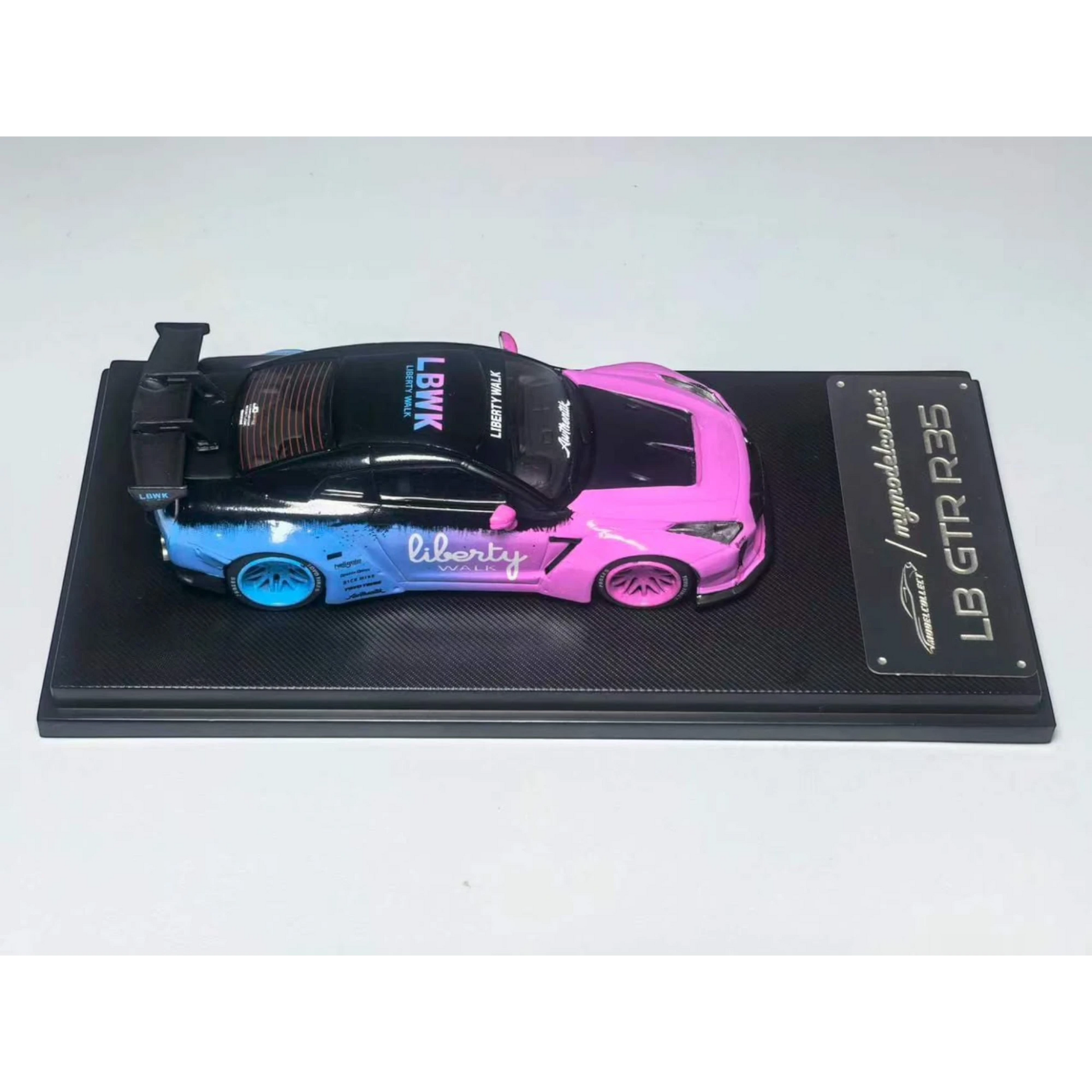Lot57Supplies Diecast Shop 1:64 scale MC LB GTR 1.5 diecast model car in flash pink and blue livery on display base