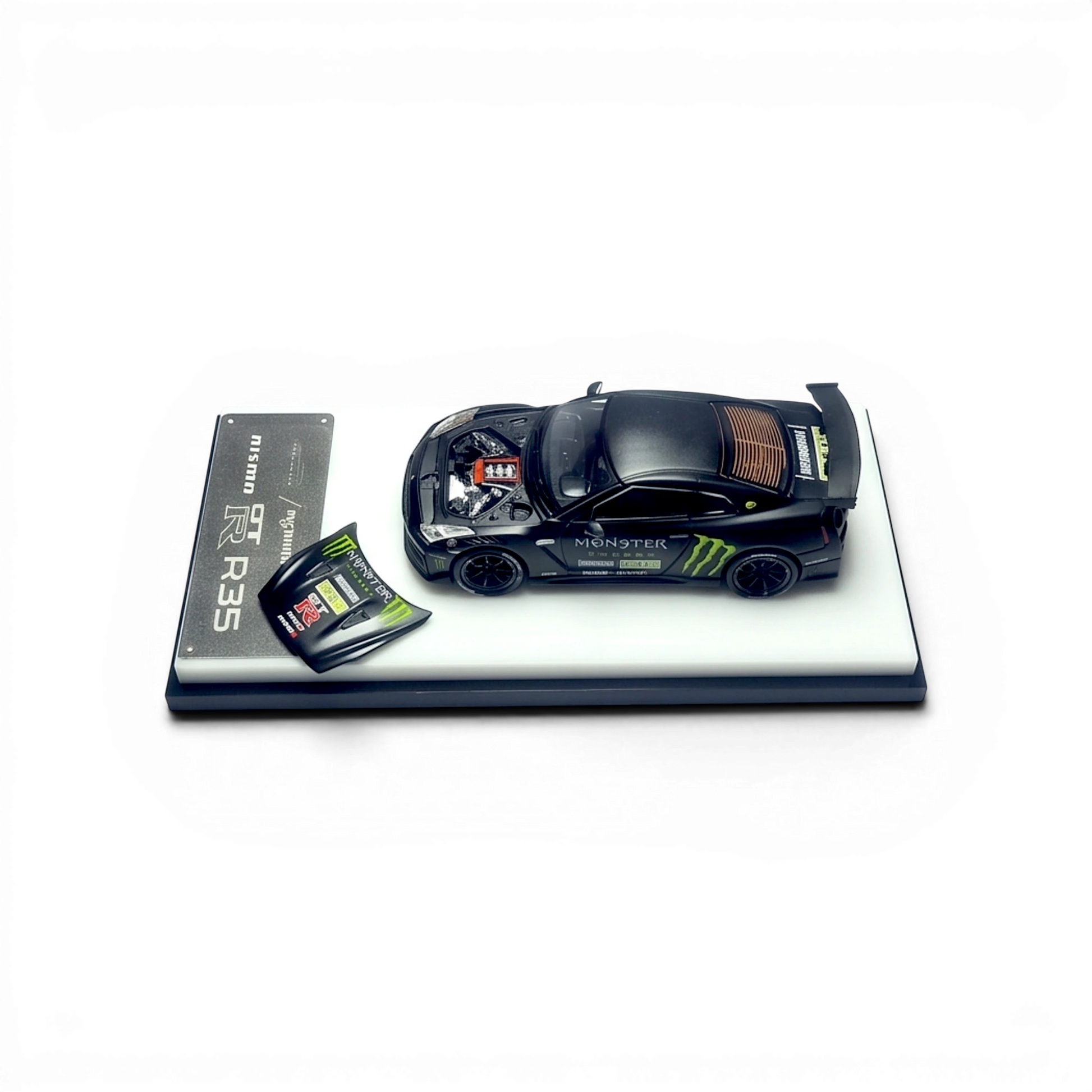 Lot57Supplies Diecast Shop 1:64 scale matte black Monster Energy GTR R35 NISMO diecast model with open hood revealing engine detail.