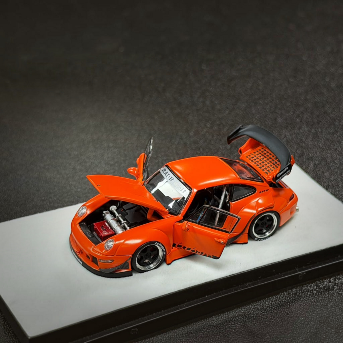 Lot57Supplies Diecast Shop PGM RWB 993 diecast model car in matte orange with opening doors, hood, and engine bay.