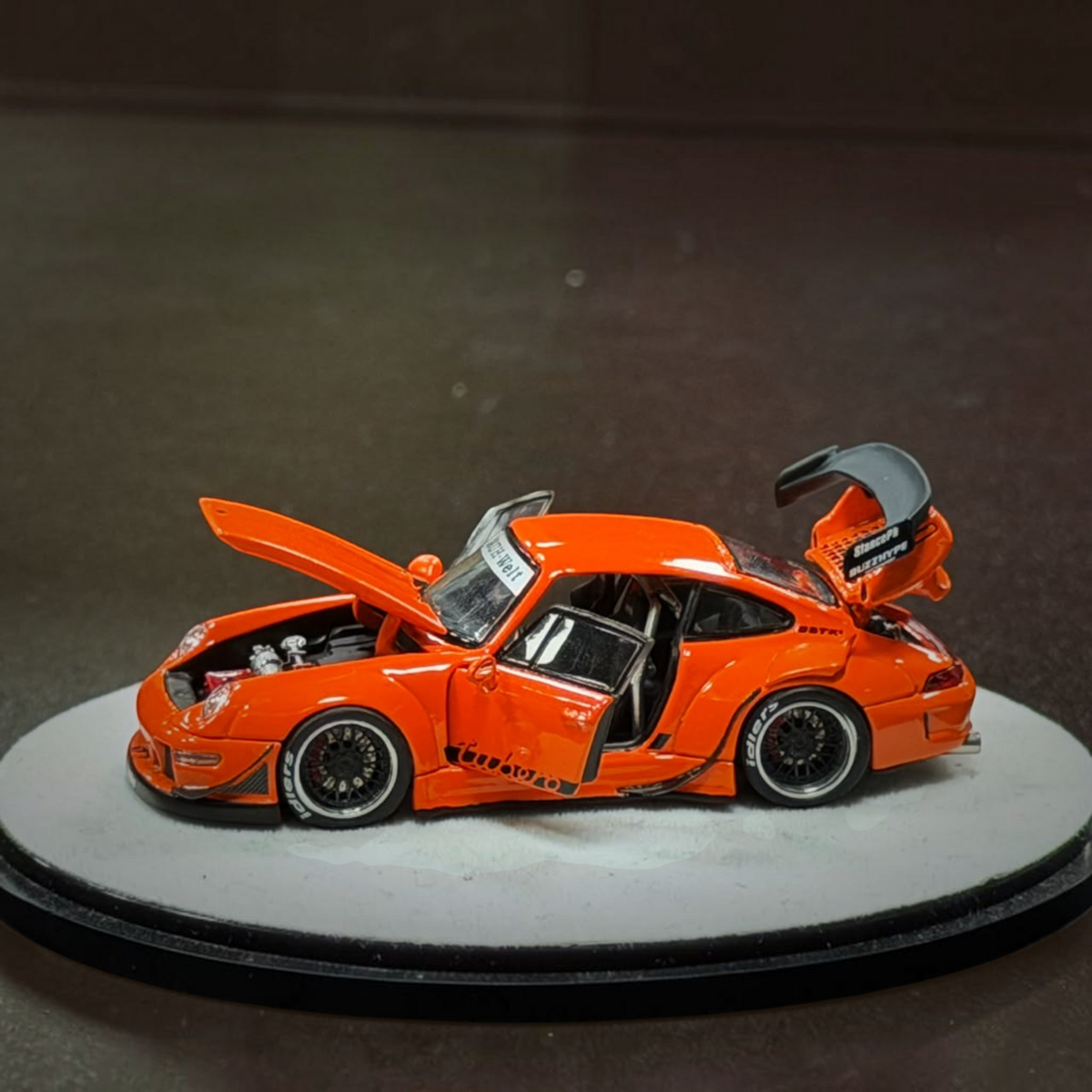 Lot57Supplies Diecast Shop PGM RWB 993 diecast model car in bright orange with opening doors, hood, and engine cover.
