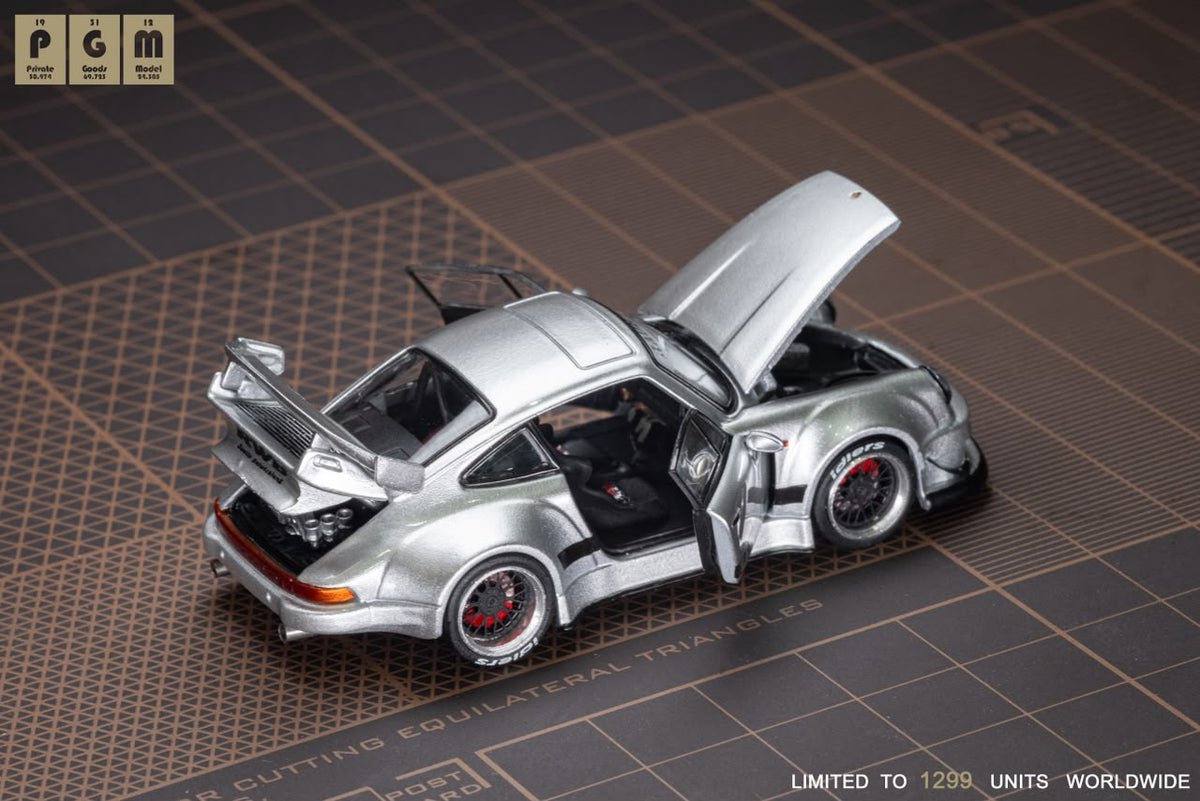 Lot57Supplies Diecast Shop PGM RWB930 silver diecast model car with open doors and hood on a cutting mat