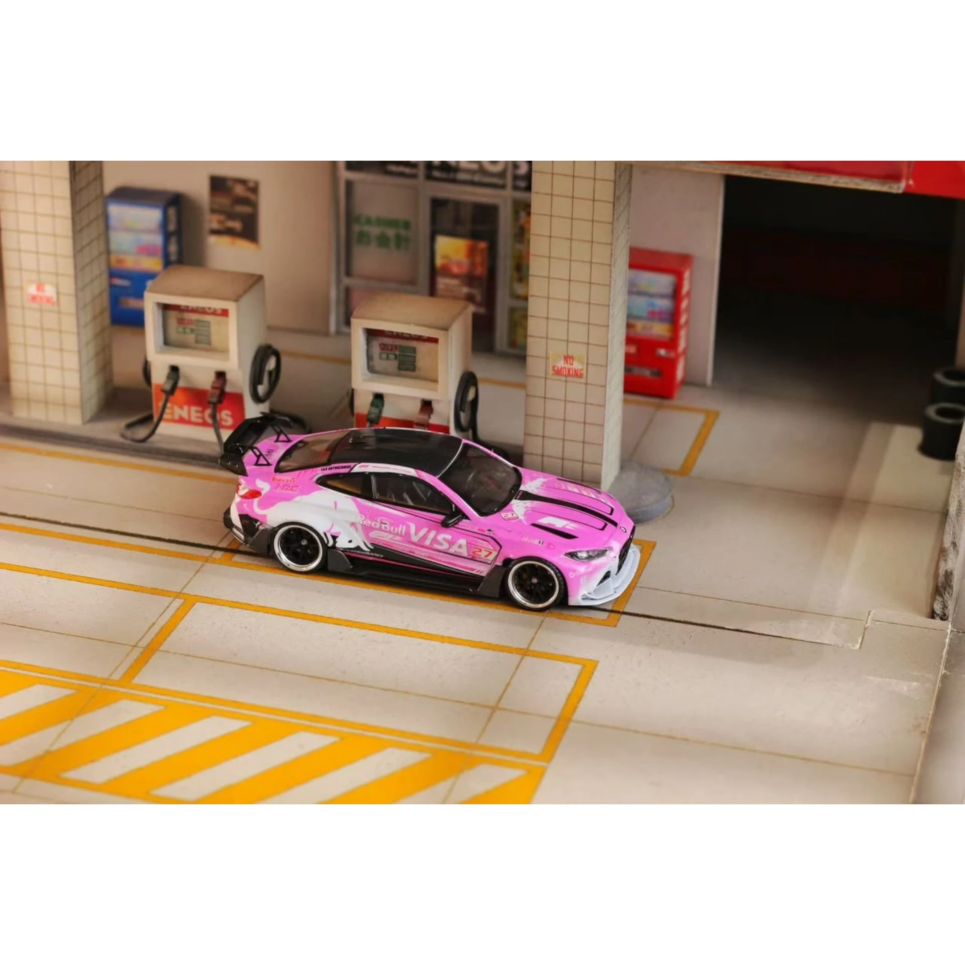 Lot57Supplies Diecast Shop 1:64 scale SW G82 M4 diecast car in pink Bull livery parked at a miniature gas station