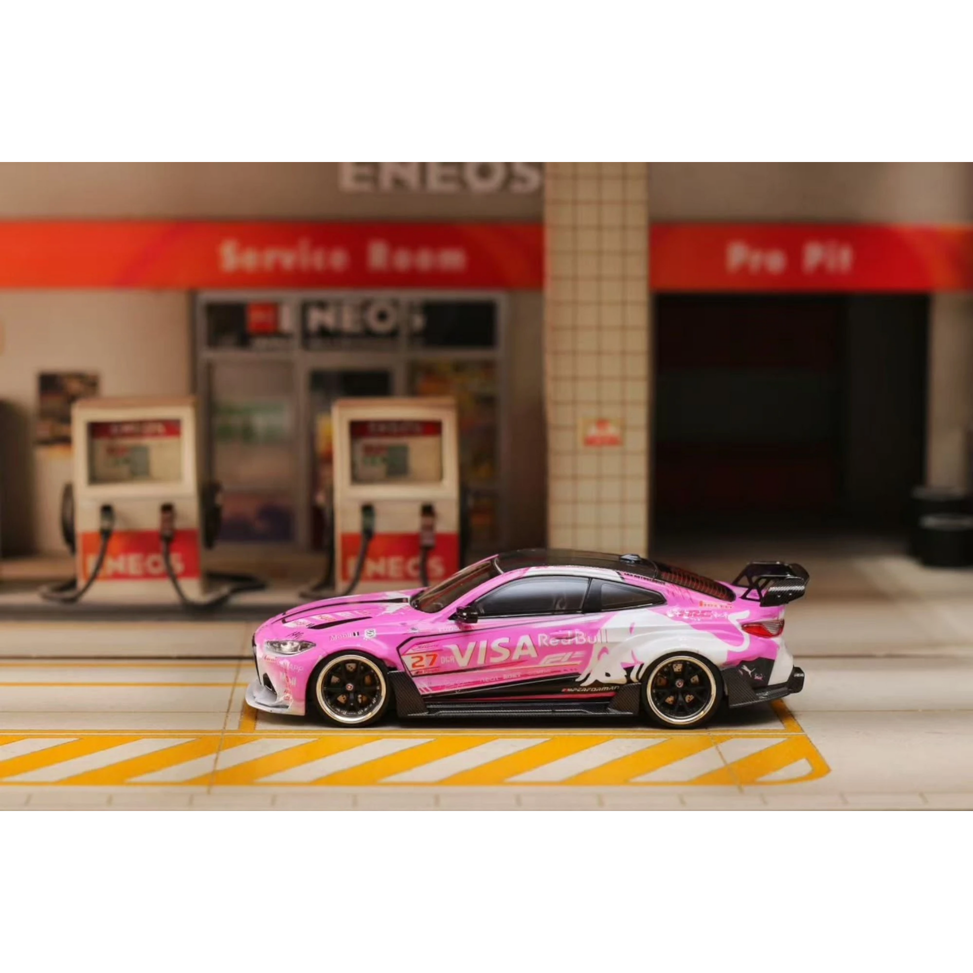 Lot57Supplies Diecast Shop 1:64 scale SW G82 M4 diecast car in pink Bull livery parked at a miniature gas station