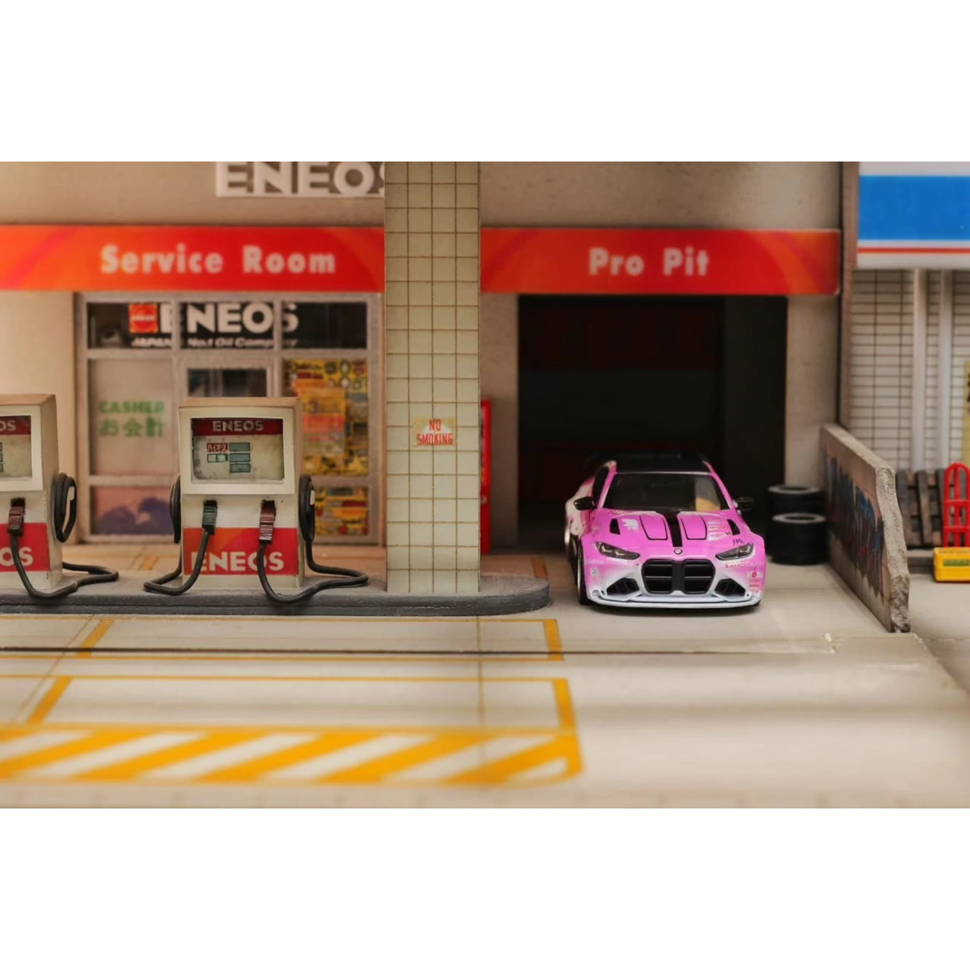 Lot57Supplies Diecast Shop 1:64 scale SW G82 M4 diecast car in pink Bull livery parked at a miniature gas station
