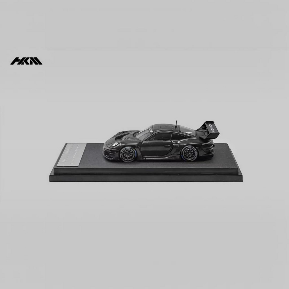 Lot57Supplies Diecast Shop HKM Porsche 911 992 GT3 R Rennsport diecast model car in gloss black on a display stand