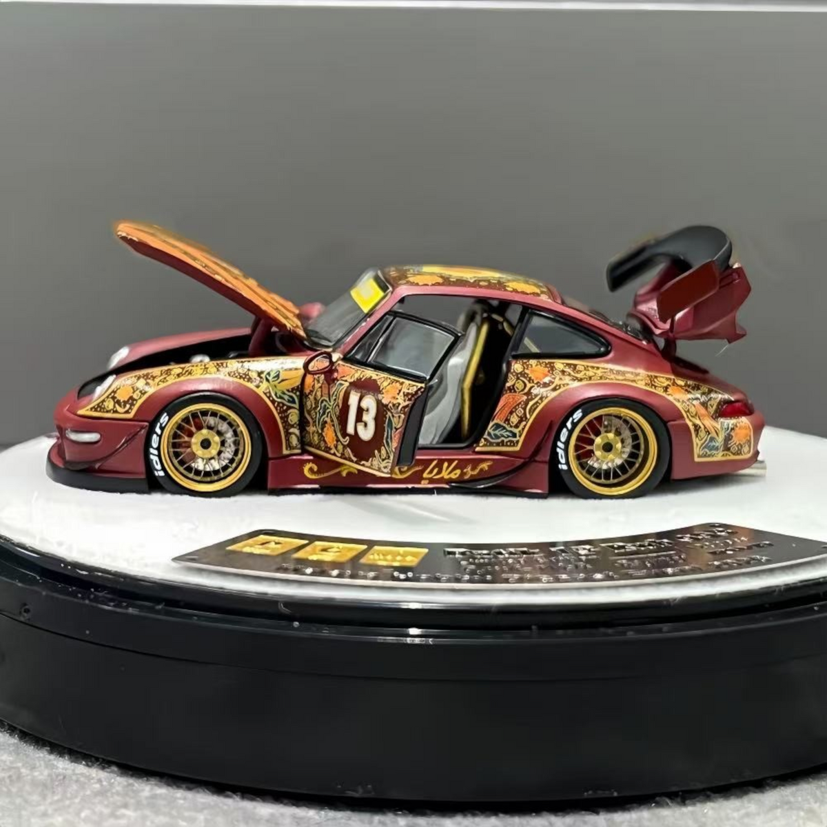 Lot57Supplies Diecast Shop PGM Porsche RWB 993 Batik 13 diecast model in red with gold alloys and intricate patterns.