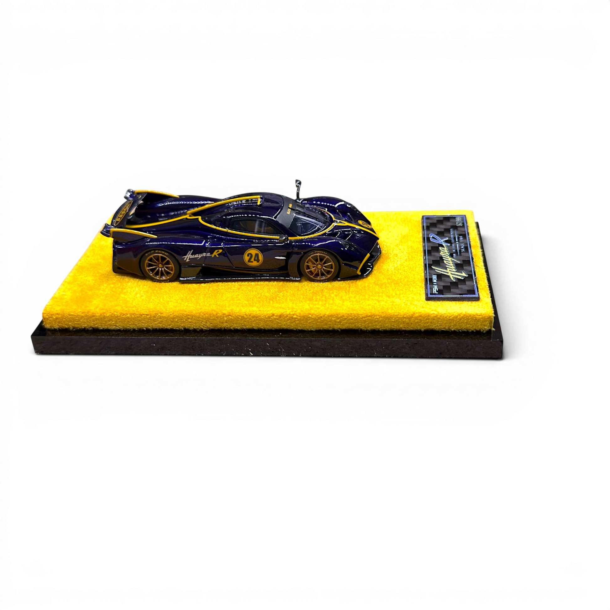 Lot57Supplies Diecast Shop 1:64 scale purple carbon fiber Pagani Huayra R model car on a yellow display base.