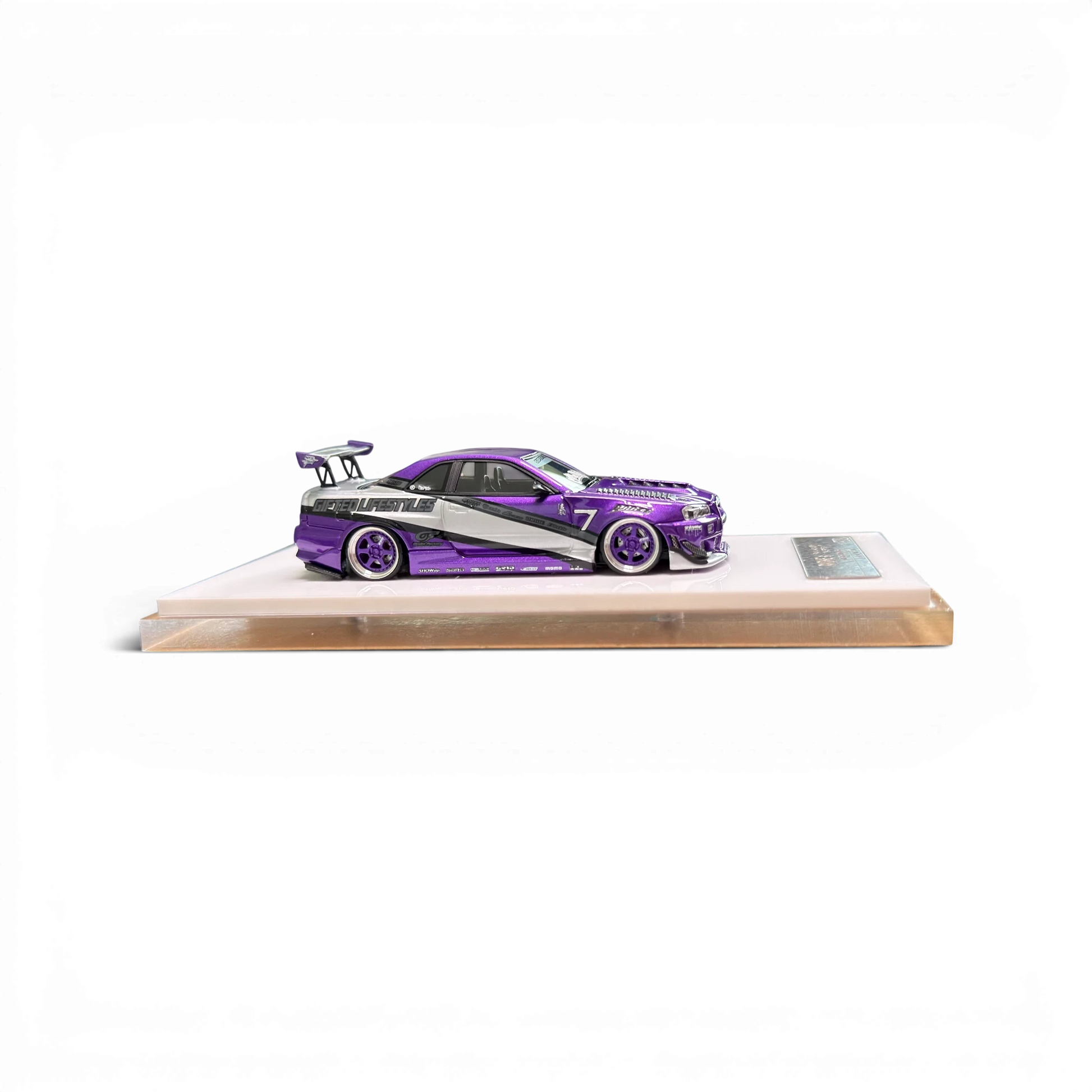 Lot57Supplies Diecast Shop 1:64 scale purple Nissan Skyline R34 GIFTED resin model car on a white display base.