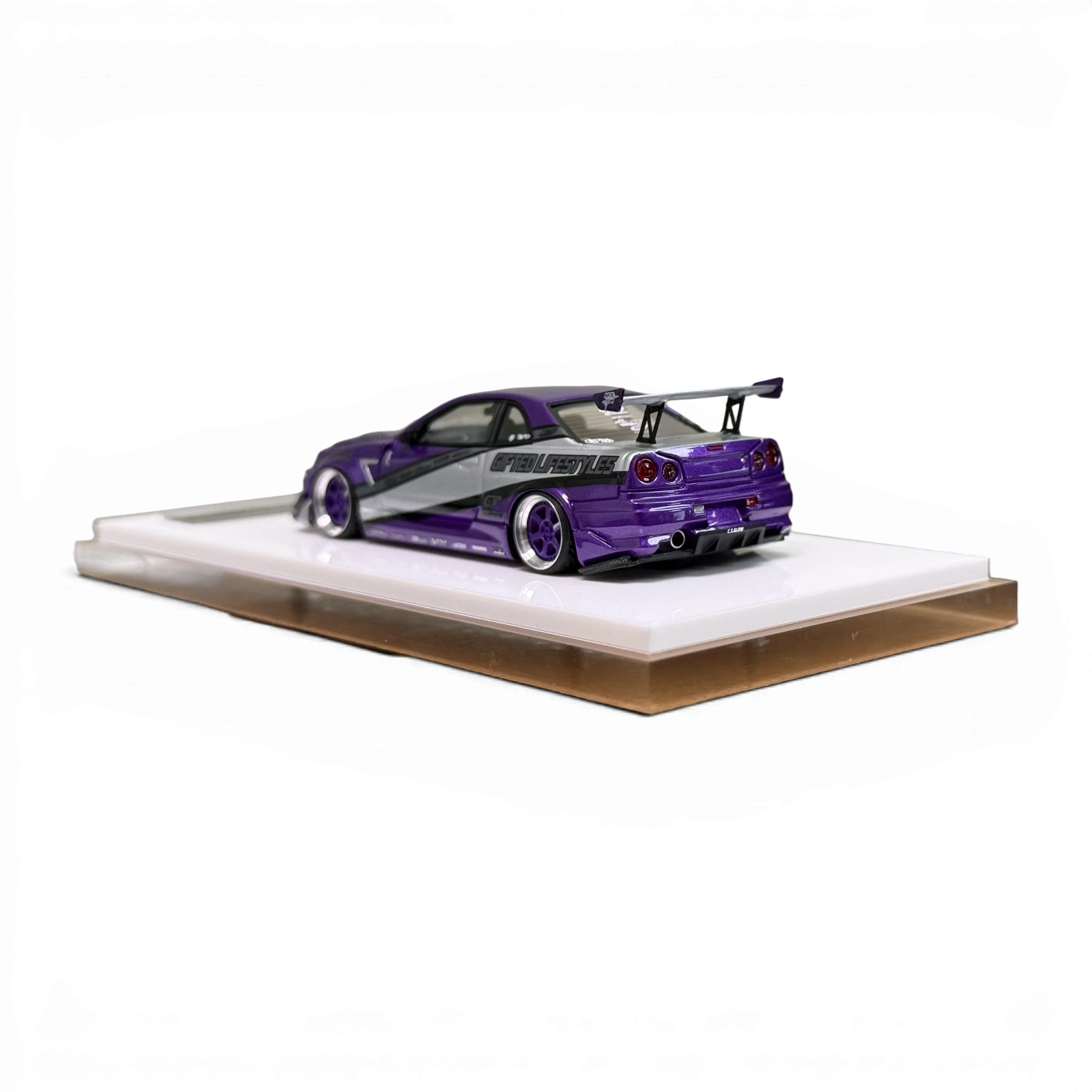 Lot57Supplies Diecast Shop 1:64 scale purple and silver Nissan Skyline R34 GIFTED resin model car on display base.