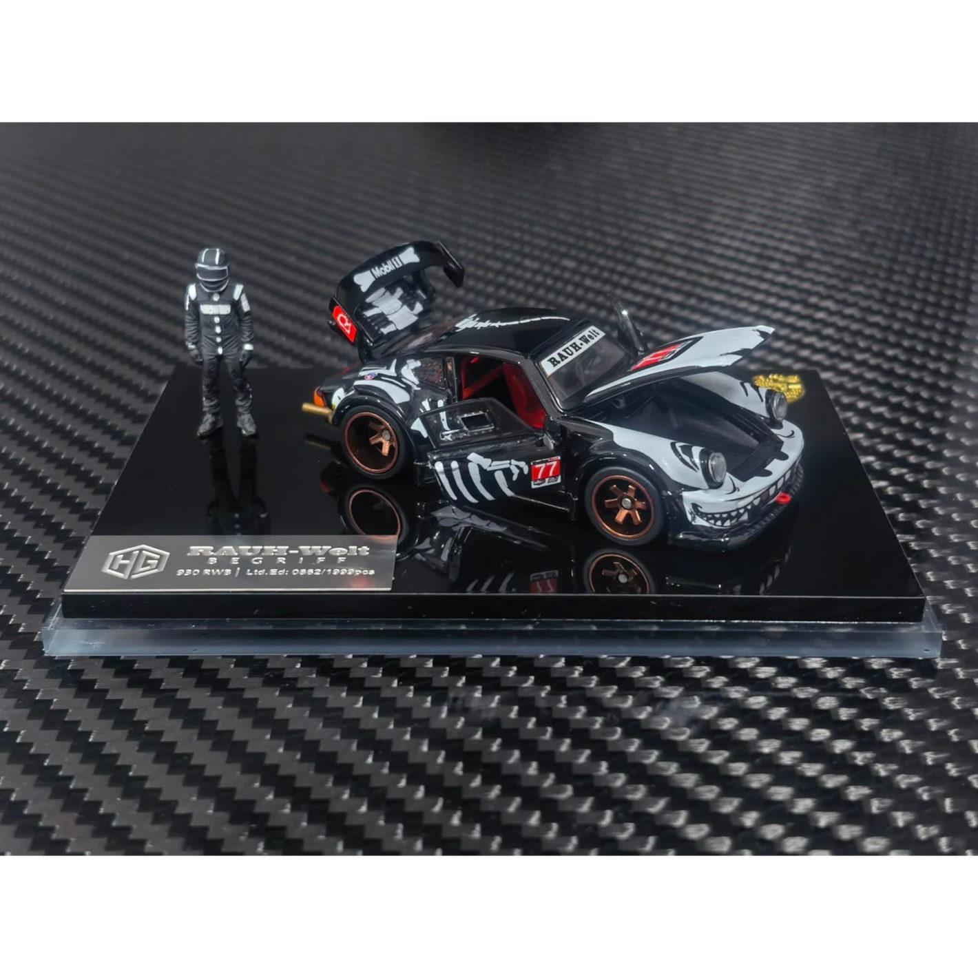Lot57Supplies Diecast Shop 1:64 scale RWB 930 diecast model car in black with white graphics and a racing driver figure.
