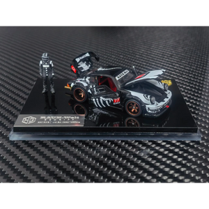 Lot57Supplies Diecast Shop 1:64 scale RWB 930 diecast model car in black with white graphics and a racing driver figure.