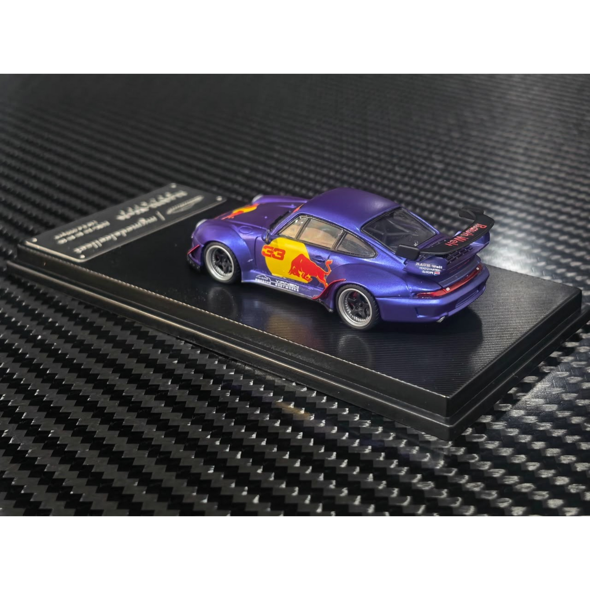 Lot57Supplies Diecast Shop 1:64 scale MC RWB993 diecast model car in matte purple with Red Bull livery and high wing.