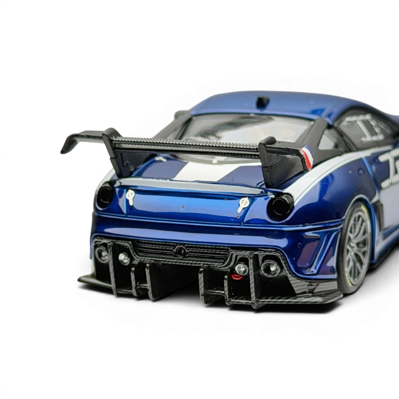 Lot57Supplies Diecast Shop metallic blue SK Model Ferrari 599XX EVO 1:64 scale diecast model with white racing stripes and large rear spoiler.