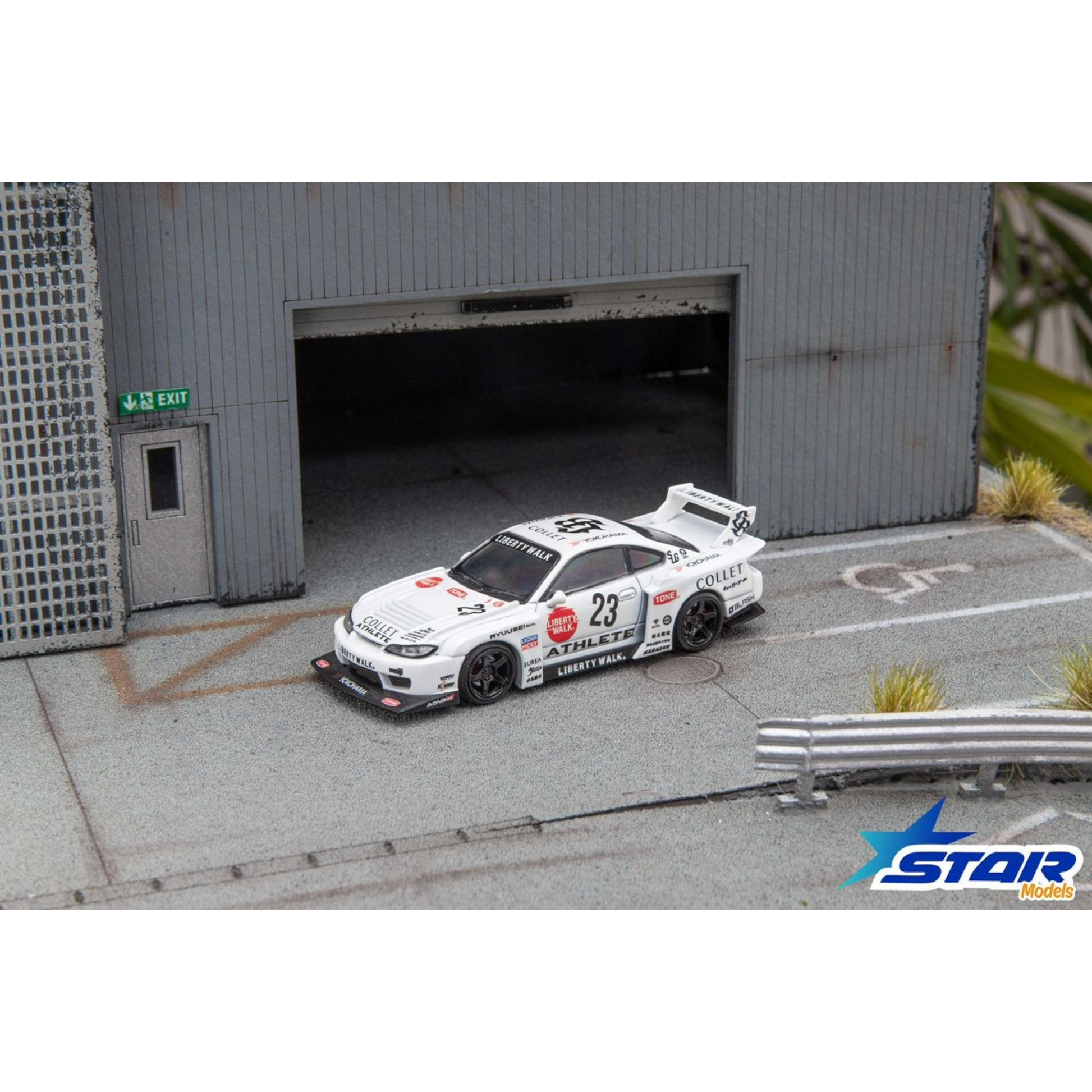 Lot57Supplies Diecast Shop 1:64 scale white Star Models S15 Silvia widebody diecast car with 23 livery in a garage