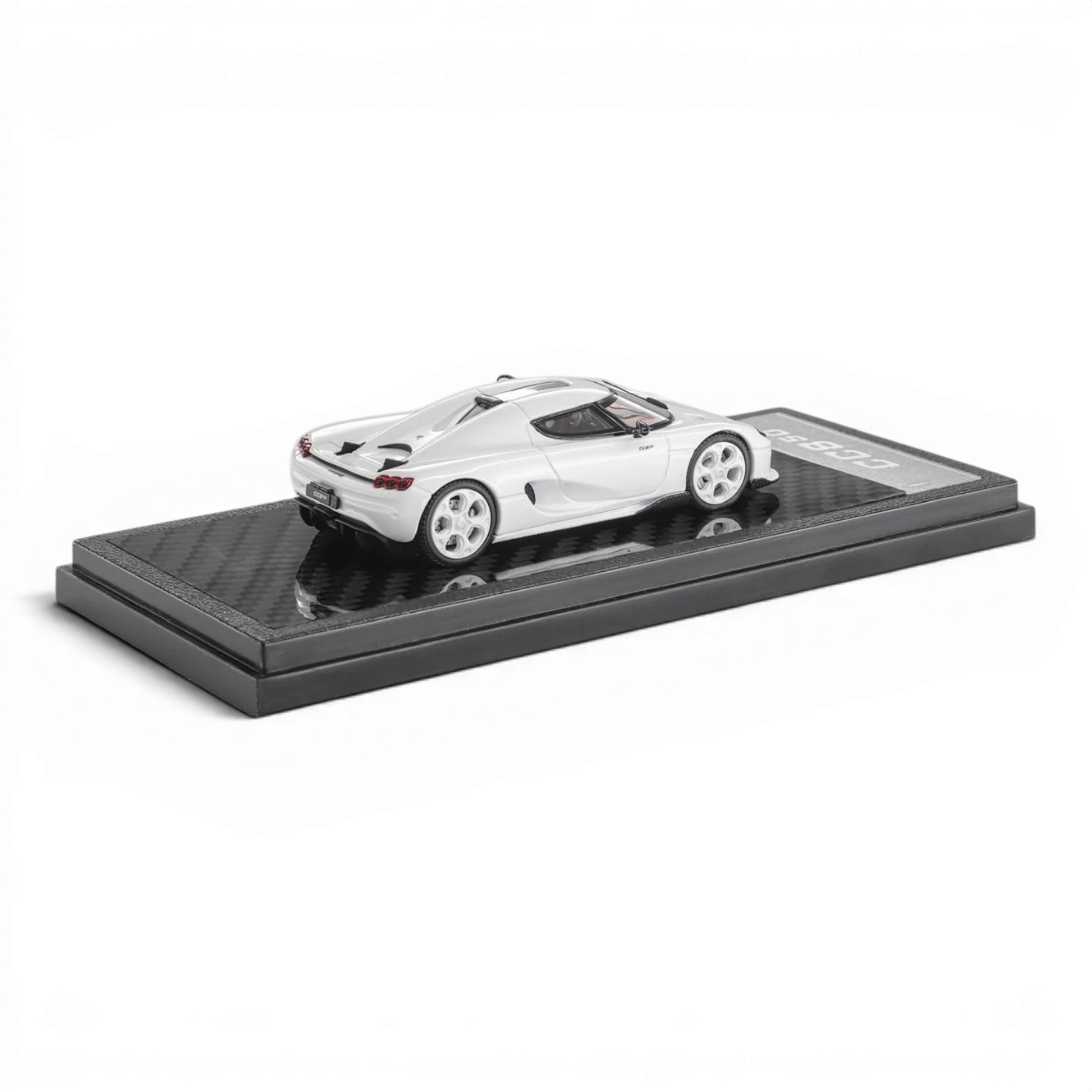 Lot57Supplies Diecast Shop 1:64 scale white Koenigsegg CC850 diecast model car on a carbon fiber display base