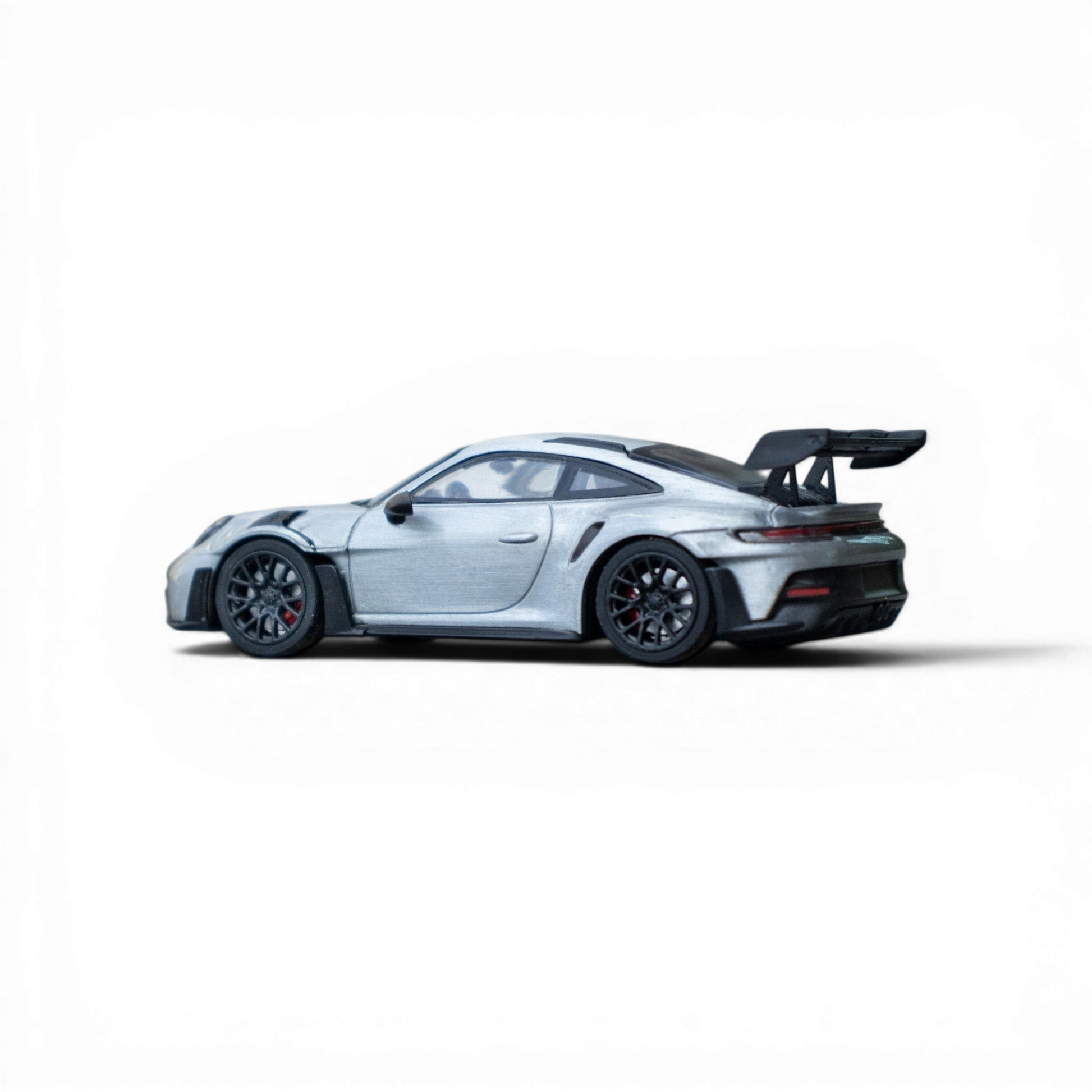Lot57Supplies Diecast Shop Minichamps Porsche 911 GT3 RS 1:64 scale raw silver diecast model with large rear spoiler.