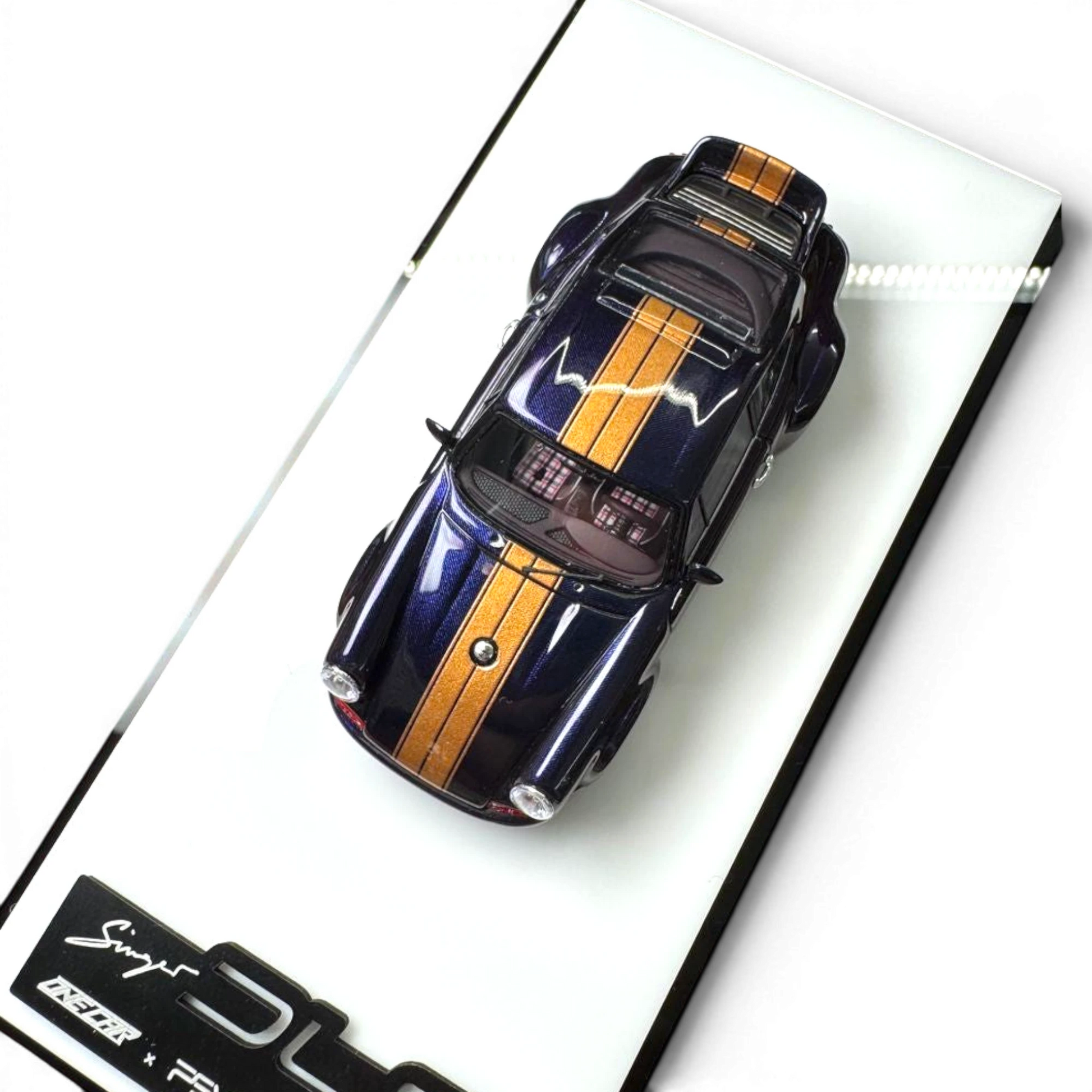 Lot57Supplies Diecast Shop 1:64 scale dark blue resin Porsche Singer DLS model with gold stripes and roof detail.